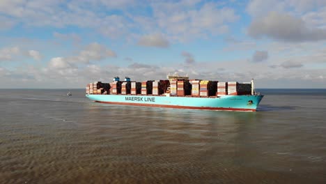 Das-Riesige-Containerschiff-Marstal-Maersk-Segelt-Halb-Beladen-In-Der-Nordsee-In-Richtung-Des-Hafens-Von-Rotterdam,-Während-Möwen-Um-Es-Herumfliegen