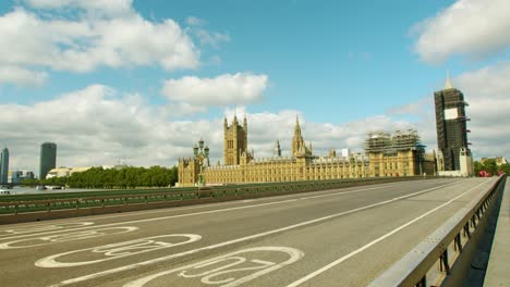 Lockdown-in-London,-cyclist-gives-thumbs-up-on-Westminster-Bridge-with-the-Houses-of-Parliament-in-summer-sunlight,-during-the-COVID-19-pandemic-2020