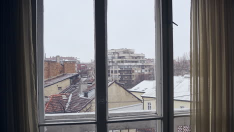 A-4K-timelapse-through-a-window-of-a-snowy,-winter-day-in-Sofia,-Bulgaria,-in-the-European-Union
