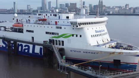 Stena-Line-freight-ship-vessel-loading-cargo-shipment-from-Wirral-terminal-Liverpool-aerial-view-pull-back-city-reveal