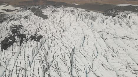 Aerial-forward-tilt-up-reveal-over-Svinafellsjokull-Glacier-and-surrounding-landscape,-Iceland