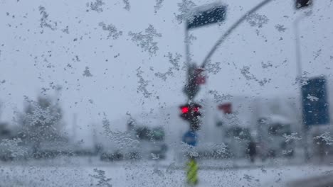 Snowfall-Sliding-On-Car-Windshield-While-Driving-On-A-Green-Traffic-Light-In-Istanbul,-Turkey