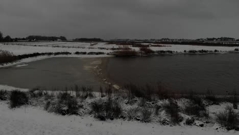 Panorama-Of-A-Countryside-By-A-Calm-Lake-During-Snowfall-In-Winter