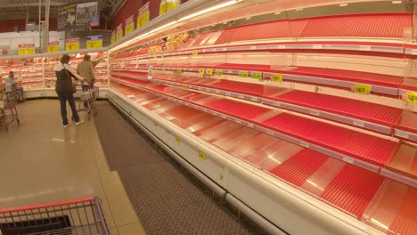 Customers-looking-for-meat-to-purchase-amid-nearly-empty-shelves-at-HEB-grocery-store-that-implemented-purchase-limits-and-reduced-hours-manage-food-shortages-after-devastating-Winter-Storm
