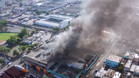 Luftaufnahme-Einer-Dichten-Schwarzen-Rauchsäule,-Die-Aus-Einer-Brennenden-Matratzenfabrik-In-Santo-Domingo-Aufsteigt