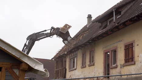 Baggerarm-Zerstört-Dach-Eines-Alten-Gebäudes
