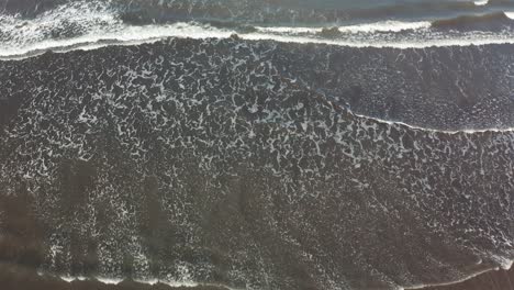 -Top-Down-View-Of-Waves-Rolling-Over-The-Beach---aerial-drone-shot