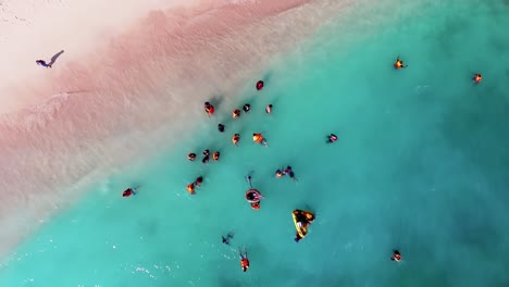 Vista-Aérea-Sobre-Un-Grupo-De-Personas-En-El-Agua-En-Una-Playa,-En-Indonesia---Destornillador,-Disparo-De-Drones