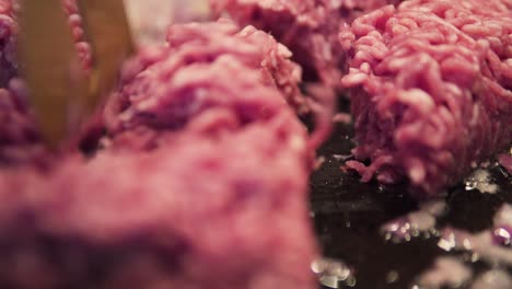close-up-of-minced-meat-being-added-into-pan-for-cooking