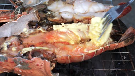 Extreme-close-up-Chef-uses-fork-to-wiping-butter-on-grilled-lobster---Thailand