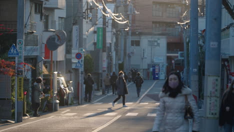 Menschen-In-Medizinischer-Maske,-Die-Bei-Sonnenuntergang-An-Einem-Sonnigen-Wintertag-Inmitten-Einer-Pandemie-In-Tokio,-Japan,-Durch-Die-Straßen-Gehen