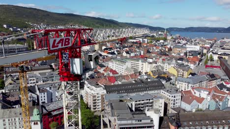 Grúa-De-Construcción-De-Laboratorio-En-Bergen,-Noruega---Antena-De-Gran-Altitud-De-La-Cabina-De-Los-Operadores-De-Grúas-Y-Vista-De-La-Ciudad-En-El-Fondo