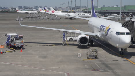 Tripulación-De-Tierra-Reabasteciendo-De-Combustible-Jet-Comercial-Boeing-737-Antes-De-La-Salida-En-El-Aeropuerto-De-Tokio,-Japón