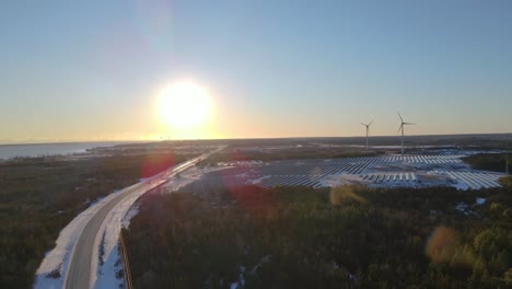 Luftflug-In-Richtung-Einer-Windmühle-Und-Eines-Solarparks-Bei-Sonnenuntergang