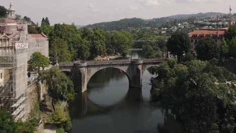 Fliegen-Sie-über-Den-Idyllischen-Fluss-Tamega-Und-Die-Brücke-Sao-Goncalo,-Amarante,-Portugal
