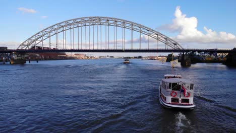 Aerial-Following-Veerboot-3-Boat-Along-River-Noord-Towards-Bridge