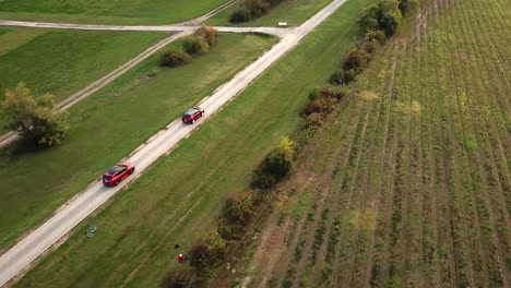 Aerial-view-of-black-and-red-Opel-Grandland-and-Ford-Kuga-cars-speeding-on-a-country-road