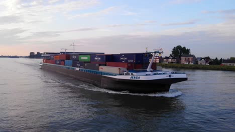 Aerial-Forward-Bow-View-Of-Jenga-Cargo-Container-Ship-Going-Past-Along-Noord-Near-Ridderkerk