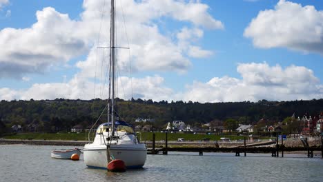 Slow-rocking-sail-boat-floating-on-calm-sea-coastal-fishing-seaside-harbour-town-gentle-tide