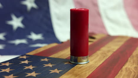 An-empty-red-shotgun-shell-on-an-American-flag--Close-up