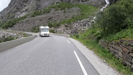Vehículos-Que-Circulan-Por-La-Carretera-De-Montaña-Trollstigen-Pasando-Por-Cascadas-En-Rauma,-Noruega
