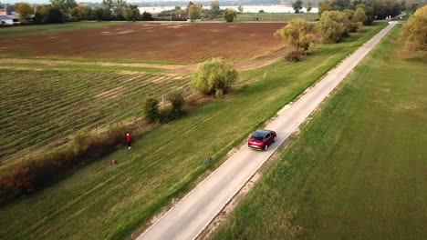 Aerial-view-of-a-black-and-red-Opel-Grandland-car-speeding-on-a-country-road