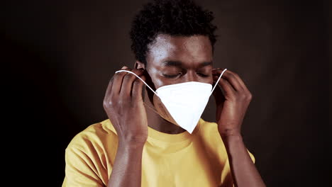 Junger-Schwarzer-Mann,-Der-Zum-Schutz-Vor-Coronaviren-Eine-N95-Gesichtsmaske-Aufsetzt