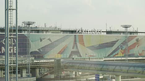 Establishing-high-view-of-Paris-Orly-airport-building-with-traffic-and-metro