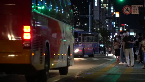 Nachtansicht-Der-Bushaltestelle-Gangnam-In-Der-Innenstadt-Von-Seoul-Mit-Menschen,-Die-Zum-Fahren-Schlange-Stehen-Und-Gesichtsmasken-Tragen,-Um-Sich-Vor-Einer-Covid-Infektion-Zu-Schützen