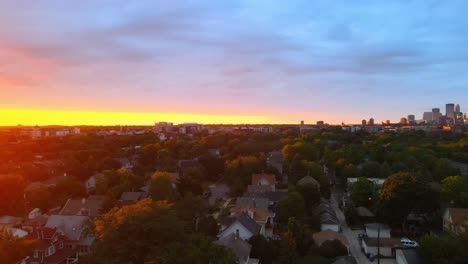 Aerial-view-of-a-beautiful-sunset-in-Minneapolis-suburbs-area-during-golden-hour,-homes-houses