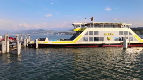 Sideways-aerial-drone-shot-of-car-ferry-Meilen-offloading-cars-on-Lake-Zürich-in-Switzerland