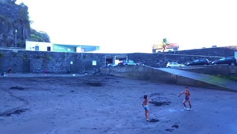 Zwei-Kleine-Jungen-Spielen-Und-Bewerfen-Sich-Gegenseitig-Mit-Sand-Am-Strand-Von-Seixal-In-Portugal