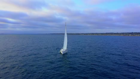 Drone-view-flying-around-a-sailboat-cruising-down-the-coast-of-southern-California-in-the-Pacific-Ocean