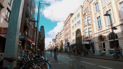 People-walking,-driving-and-cycling-in-Martelarenplein,-downtown-Leuven,-Belgium