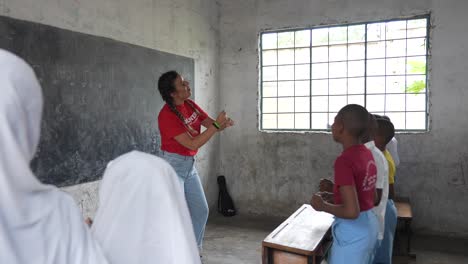White-caucasian-volunteer-teaching-and-dancing-music-with-african-kids-at-school