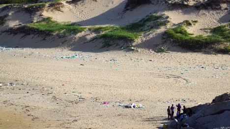 Gruppe-Von-Menschen,-Die-Den-Mit-Plastikmüll-Verschmutzten-Strand-An-Der-Küste-Vietnams-Reinigen