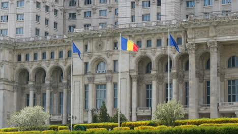 Banderas-Ondeando-Frente-Al-Palacio-Del-Parlamento-En-Bucarest,-Rumania