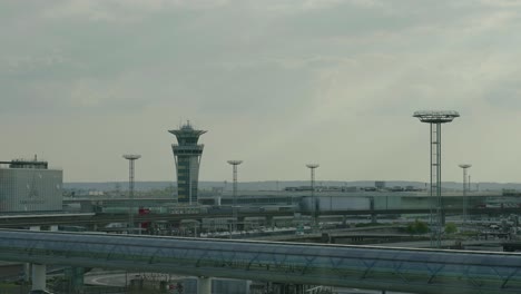 Panning-view-from-cloudy-sky-to-Paris-Orly-airport-building-and-road