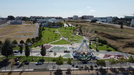 Aerial-View-Of-Ferris-Wheel-With-Greener-Park-As-Background-In-Seixal,-Portugal---drone-shot