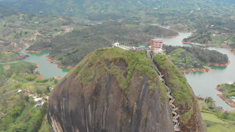 Vista-Aérea-Del-Monolito-Piedra-Del-Peñol-Gran-Piedra-Negra-En-Guatape,-Antioquia---Sitio-Turístico-De-Colombia---Tiro-Con-Drones