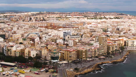 Vast-cityscape-of-Torrevieja-on-sea-coastline,-aerial-high-angle-view