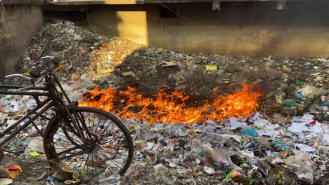 Vertedero-Lleno-De-Basura-Ardiendo-Con-Llamas-Naranjas-En-Dhaka