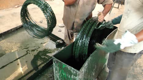 Rolled-Up-Barbed-Wire-Security-Fence-Being-Dipped-In-Oil-At-Factory-In-Karachi
