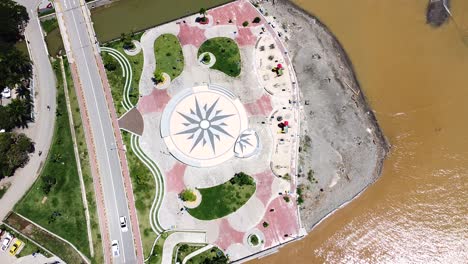 Ein-Leerer-Kinderspielplatz-Mit-Vorbeifahrendem-Verkehr-Und-Braunem,-Trübem-Meer-Nach-Sturzfluten-In-Dili,-Timor-Leste,-Südostasien---Drohne-Aus-Der-Vogelperspektive