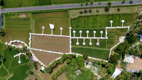 Aerial-top-down-descendent-over-green-rice-fields-and-restaurant-at-Muntilan-in-Indonesia