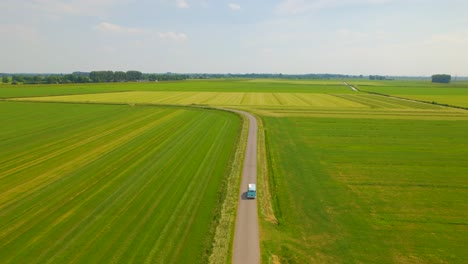 Classic-Volskwagen-van-driving-through-countryside,-aerial-view