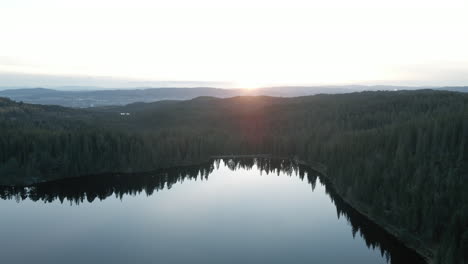 Ruhiges-Wasser-Des-Sees,-Umgeben-Von-Nadelwald-Bei-Sonnenaufgang