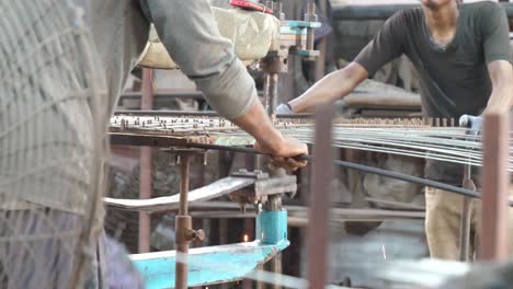 Factory-Workers-Using-Spot-Weld-Machine-On-Reinforcement-Wire-Mesh-In-Karachi,-Pakistan