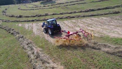 hay-being-raked-in-field-at-harvest-time-aerial