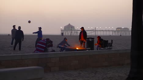 Friends-enjoying-the-evening-around-a-fire-pit-in-Huntington-Beach,-California